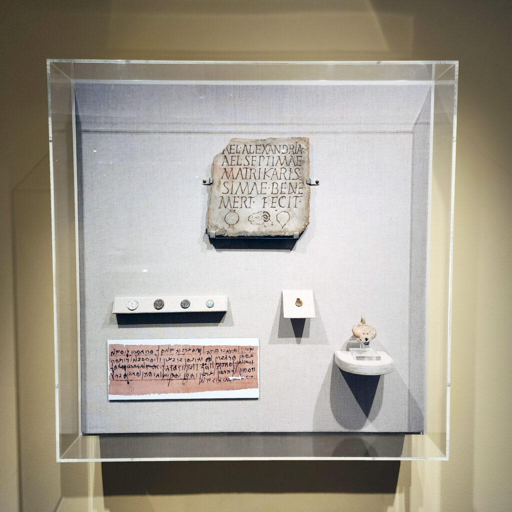 An exhibit case containing coins and inscriptions.