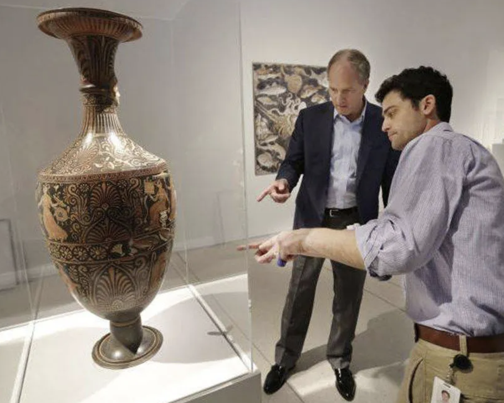Tampa Museum Director Todd Smith (left) and Chief Curator Seth Pevnick (right) examine part of the Poseidon exhibit — Photo: Tampa Museum of Art