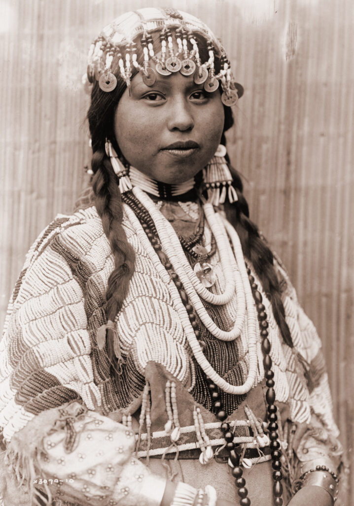 Figure 4. Portrait of a Wishram (a Columbia River people of Oregon) bride wearing headdress decorated with Qing Dynasty tong bao. Photographed by Edward Curtis, c. 1910.