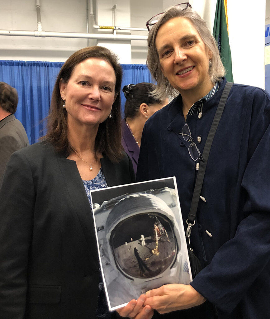 Ann Collins Starr (l.) and Sculptor-Engraver Phebe Hemphill (r.) holding photo of 'Buzz Aldrin on the Moon' taken July 20, 1969.